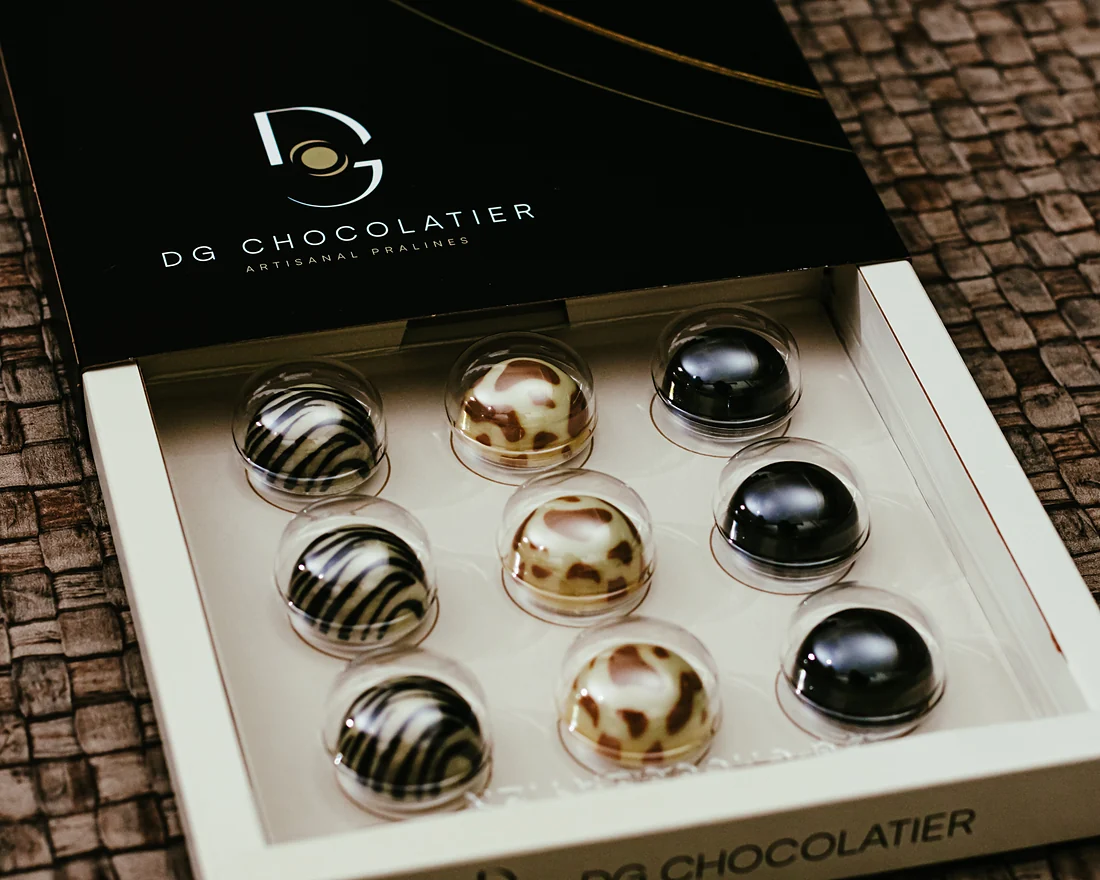 A black box of nine pralines, opened