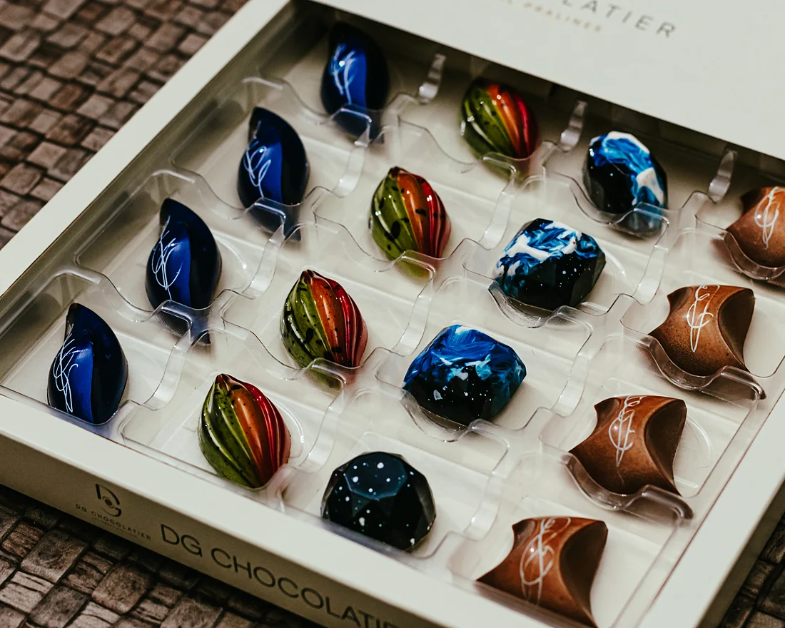 Sixteen pralines in their box, seen close